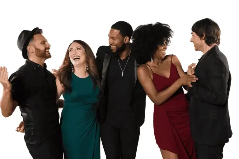 Group of five people laughing and interacting together in a studio setting.